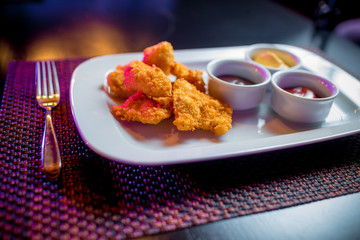 хрустящие наггетсы из индейки с соусами на терелке
