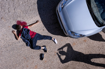Aerial View of a teenager, who has been run over with a car.