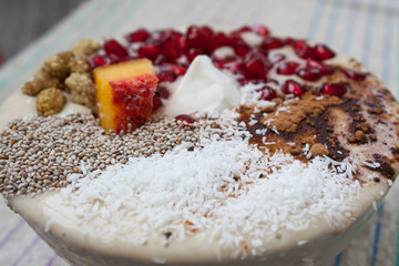 vegan banana smoothie with pomegranate, mulberry, coconut, Chia, carob. Raw fruit energy food. Detof and healthy breakfast bowl. 