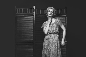 Beautiful girl standing near folding screen 