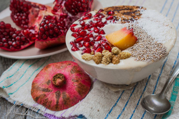 vegan banana smoothie with pomegranate, mulberry, coconut, Chia, carob. Raw fruit energy food. Detof and healthy breakfast bowl. 