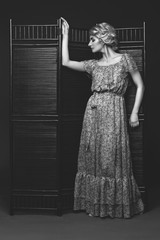 Beautiful girl standing near folding screen 