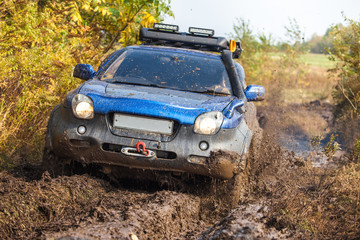 Naklejka na ściany i meble Japanese off-road car moving through deep mud