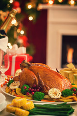 Christmas turkey dinner in front of Christmas tree near fireplace