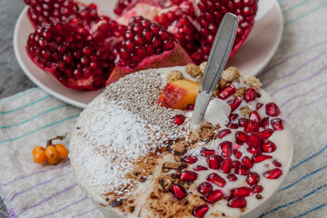 vegan banana smoothie with pomegranate, mulberry, coconut, Chia, carob. Raw fruit energy food. Detof and healthy breakfast bowl. 