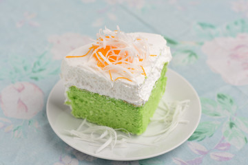 Green pandan cake with fresh cream and fresh sliced coconut on top