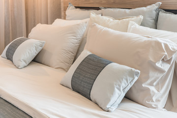 set of pillows on modern bed in bedroom interior