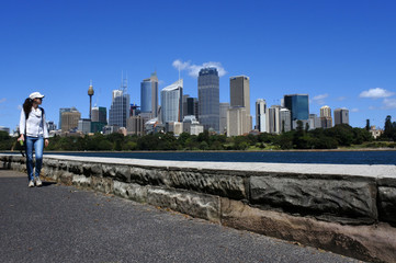 Fototapeta na wymiar Woman walks along Sydney skyline