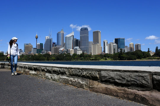 Woman walks along Sydney skyline