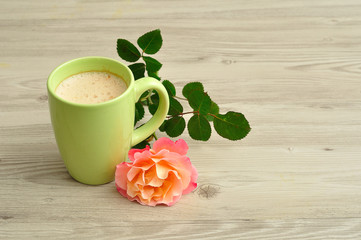 A mug of coffee with an orange rose