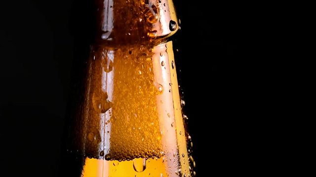 extreme close up of bottle of beer with water drop falling