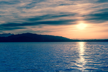 Fantastic evening at the lake. Sun sets behind the horizon.