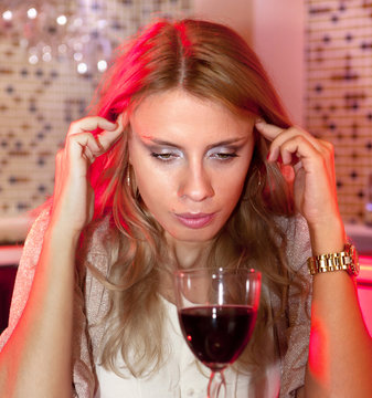 sad woman with glass of red wine
