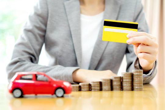 Businesswomen hand with credit card and  many coins with car