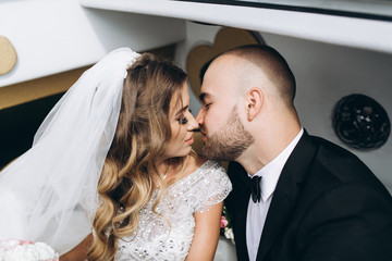 Stylish bride and bearded muscular groom posing on the wedding