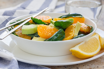 Asian style healthy spinach, avocado and orange salad with ginger-vinegar dressing, horizontal