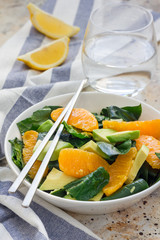 Asian style healthy spinach, avocado and orange salad with ginger-vinegar dressing, vertical