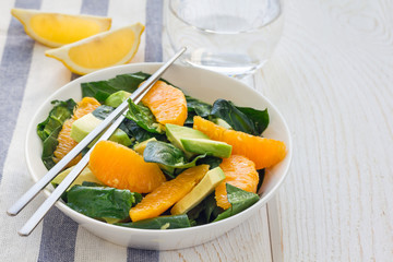 Asian style healthy spinach, avocado and orange salad with ginger-vinegar dressing, horizontal, copy space