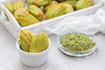 Homemade matcha green tea madeleines on the table and in wooden tray, horizontal