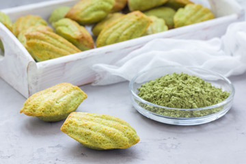 Homemade matcha green tea madeleines on the table and in wooden tray, horizontal