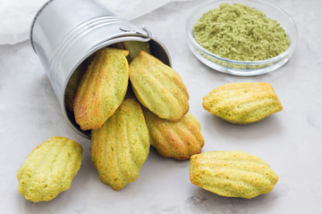 Homemade matcha green tea madeleines on the table and in metal bucket, horizontal