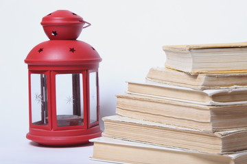 stack of old books. red lamp with candle