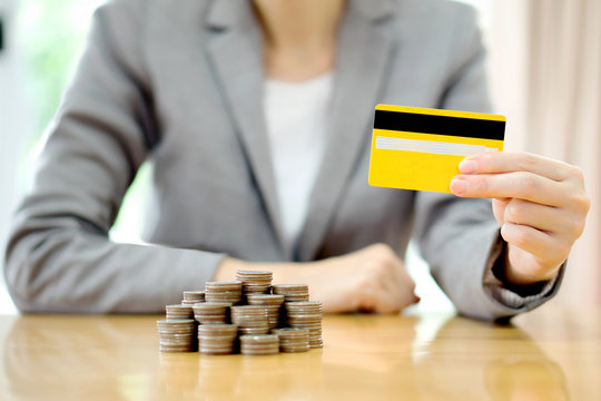 Businesswomen hand with credit card and  many coins in column