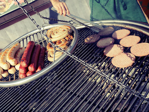 Cooking sausages and burgers on the grill