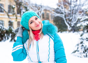 Young happy woman enjoy snow in winter city park outdoor