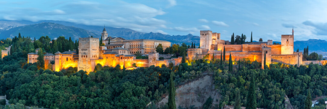 Panorama of Moorish palace and fortress complex Alhambra with Comares Tower, Alcazaba, Palacios Nazaries and Palace of Charles V during evening blue hour in Granada, Andalusia, Spain
