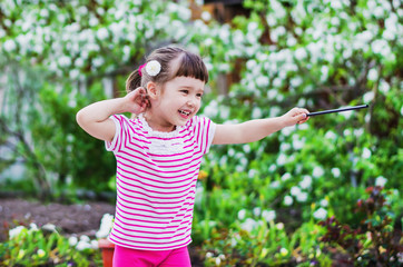 Cheerful little girl is a magician