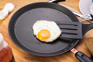 fried eggs on a pan. Pan stands on a wooden table. view from abo