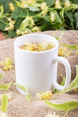 Linden tea in a cup on a wooden background.