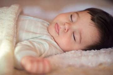 Sleeping baby covered with knitted blanket