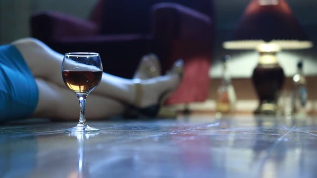 woman with alcohol sitting on the floor