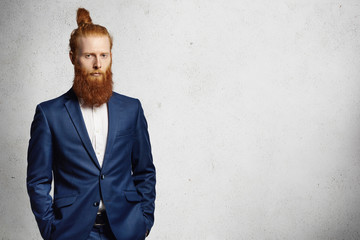 Business, formal style and fashion. Good-looking redhead bearded entrepreneur with stylish hair bun...