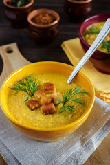 Cream soup with toasts in a yellow bowl