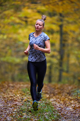 Young woman trail running in the forest