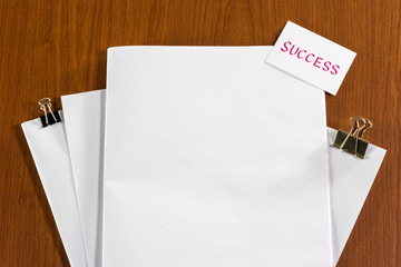 Success; White Blank Documents with Small Message Card.