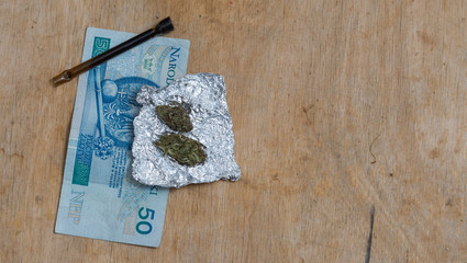 portion of  Marijuana in tin foil with pipe and Polish PLN money