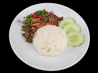 Rice topped with stir fried hot and spicy pork with basil isolated on the black background with clipping path