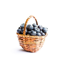 blueberries  in wicker basket isolated on white background