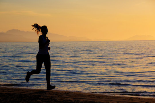 Caucasian woman jogging at seashore
