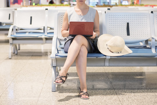Woman holding laptop and waiting at airport