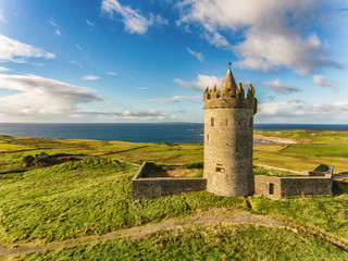 Aerial Famous Irish Tourist Attraction In Doolin, County Clare, Ireland. Doonagore Castle is a round 16th-century tower Castle. Aran Islands and along The Wild Atlantic Way. - 126015004