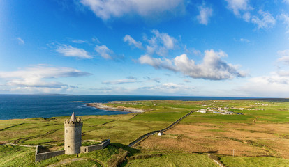 Aerial Famous Irish Tourist Attraction In Doolin, County Clare, Ireland. Doonagore Castle is a round 16th-century tower Castle. Aran Islands and along The Wild Atlantic Way. - 126015013