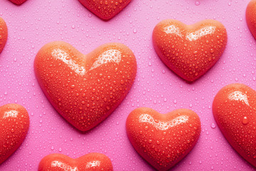 Obraz na płótnie Canvas Red hearts on pink background