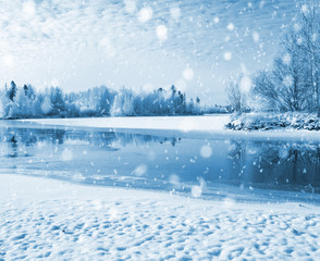 Winter landscape with frozen river and forest in the frost