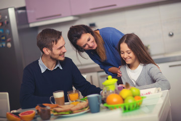 Happy family having breakfast together at home in the kitchen