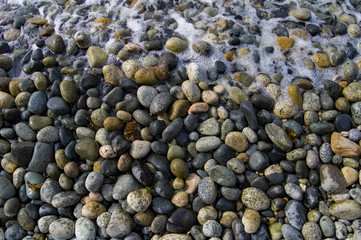 Beach rocks on shore with wave 